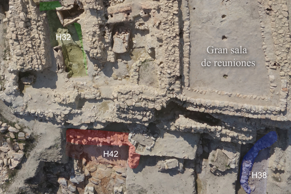 Podéis ver coloreados los restos de muros de esas primeras casas con tendencia curvilínea y algunos otros rectilíneos; son sólo los zócalos, ya que el alzado se hacía con barro amasado y postes para sostener el techo también de barro y ramaje. Estas casas las construyeron al abrigo de los vientos en la zona baja de la cima del cerro, que presentaba un fuerte buzamiento hacia el Este. La tendencia a la horizontal que vemos hoy se debe a la acumulación de restos constructivos a lo largo del tiempo.