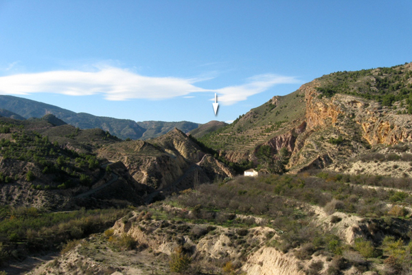 Viniendo desde el valle del Guadalentín, incluso a unos 80 metros sobre el cauce de la rambla Lébor, apenas se divisa el cerro de La Bastida.